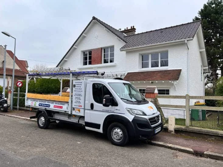 Camion benne Eco-Toit-Renov avec échelles devant un chantier